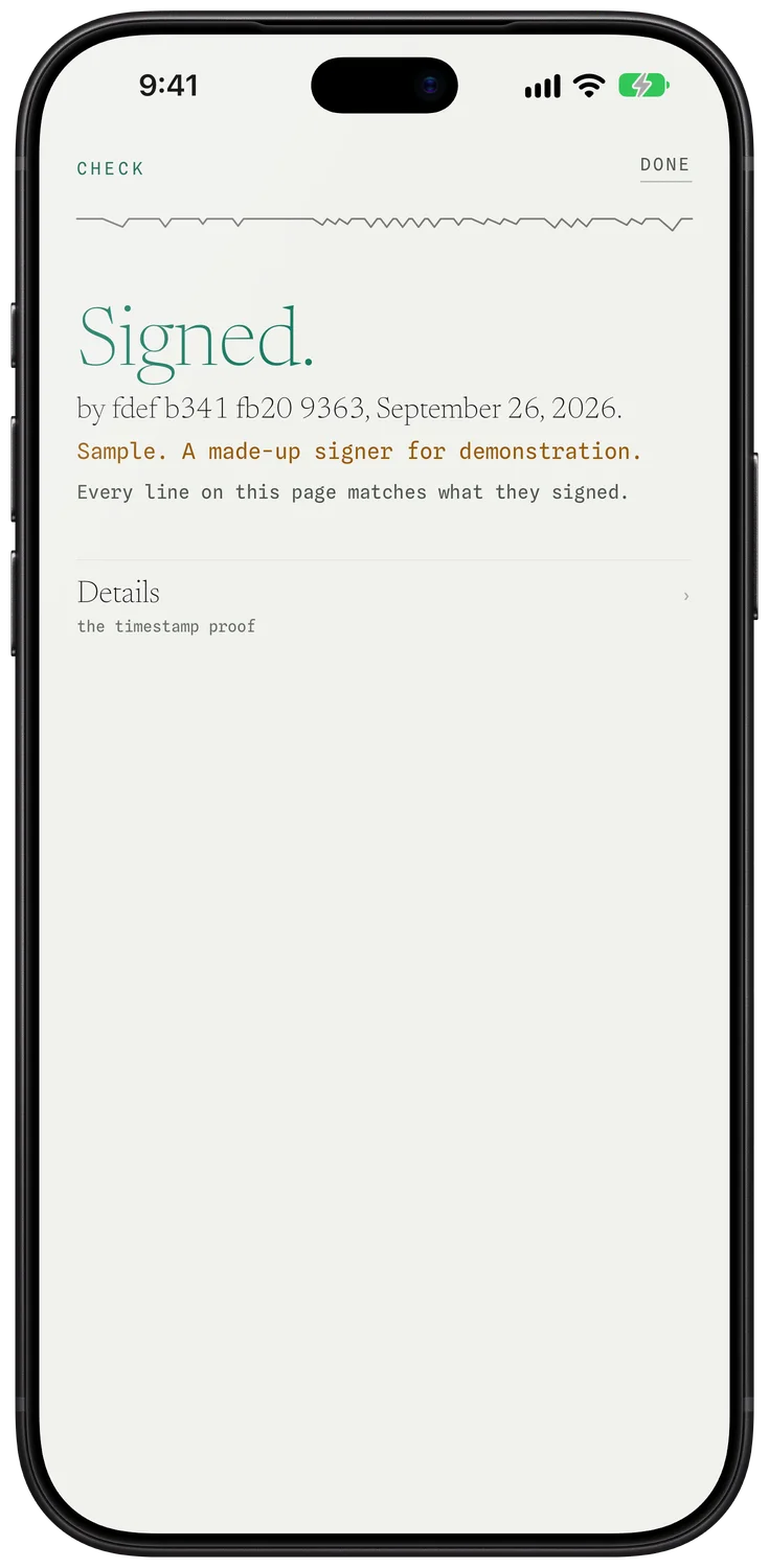 A phone held over a page, reading Signed